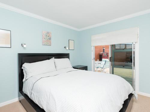 a bedroom with a white bed and a window at Captain's Quarters - Opua Holiday Home in Opua