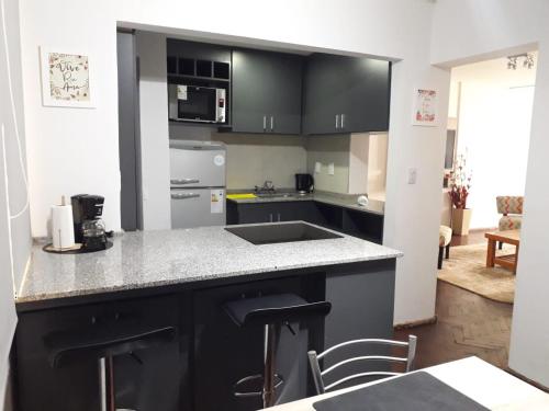 cocina con armarios negros y encimera en Departamento Ideal Super Centrico!! en Mendoza