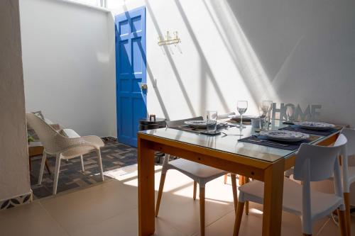 a dining room with a table and chairs and a blue door at Azulado Jericó in Jericó