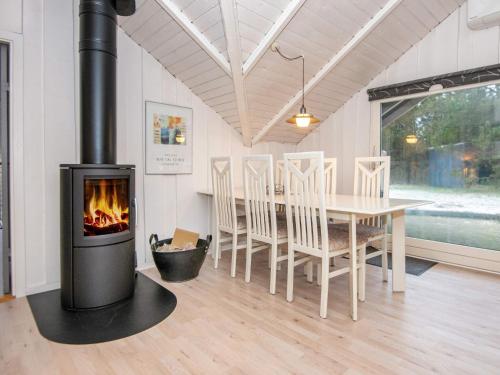 a fireplace in a living room with a table and chairs at 6 person holiday home in Ringk bing in Klegod