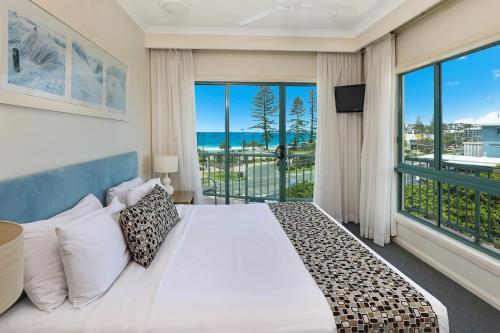 sypialnia z łóżkiem i dużym oknem w obiekcie Alex Seaside Resort w mieście Alexandra Headland