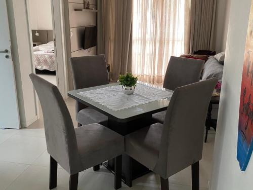une table à manger avec des chaises et une table avec une plante. dans l'établissement Ingleses Apart Wifi 200mb, à Florianópolis