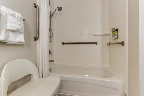 a small bathroom with a toilet and a bath tub at Holiday Inn Express - Cincinnati North - Monroe by IHG in Monroe