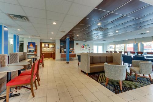 a lobby with tables and chairs and a cafeteria at Holiday Inn Express - Cincinnati North - Monroe by IHG in Monroe