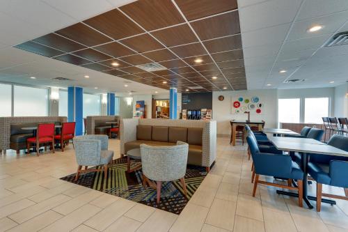 a lobby with tables and chairs and a waiting room at Holiday Inn Express - Cincinnati North - Monroe by IHG in Monroe