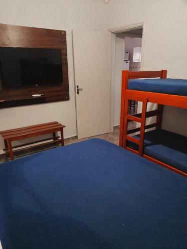 オリンピアにあるCasa em Olímpiaのベッド1台、薄型テレビが備わる客室です。