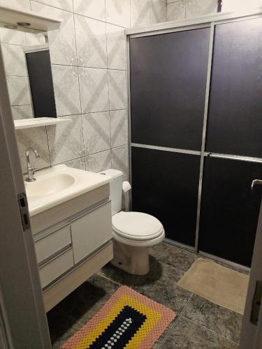 uma casa de banho com um WC branco e um lavatório. em Casa em Olímpia em Olímpia