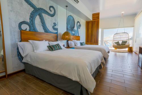 ein Hotelzimmer mit 2 Betten und einem großen Fenster in der Unterkunft Amaka Ocean Living Lodge in Golfito