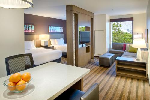 a hotel room with two beds and a table with a bowl of fruit at Hyatt House Seattle Downtown in Seattle