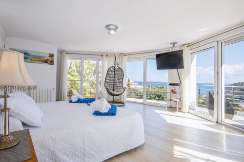a bedroom with a bed with a swing and large windows at Villa Suria in Jávea
