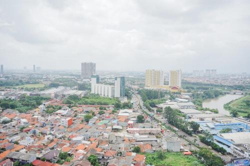 an aerial view of a city with buildings and a river at Modern Studio Apartment at Tree Park Cikokol By Travelio in Kebun Nanas