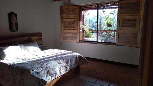 1 dormitorio con cama y ventana en La Casona Del Retiro, en Medellín