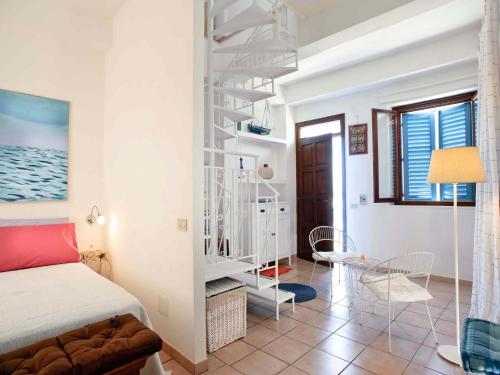 a bedroom with a bed and a spiral staircase at Casa Marettimo in Marettimo