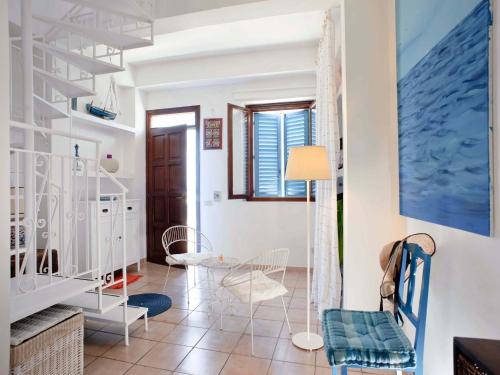 sala de estar con escalera, mesa y sillas en Casa Marettimo, en Marettimo