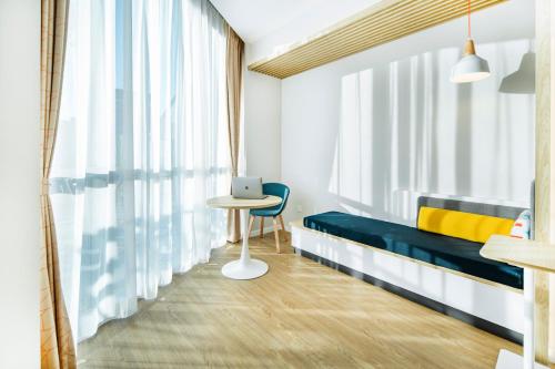 a room with a bed and a table with a laptop at Holiday Inn Express Shanghai Pudong Zhangjiang by IHG - 20 minutes to New International Expo Center and Disneyland in Shanghai
