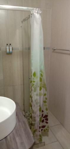 a shower with a glass door next to a sink at LightStone Guesthouse in Centurion