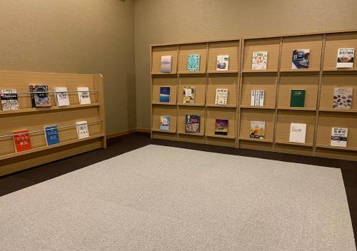 a room with shelves with books and a rug at Atami Fuga in Atami