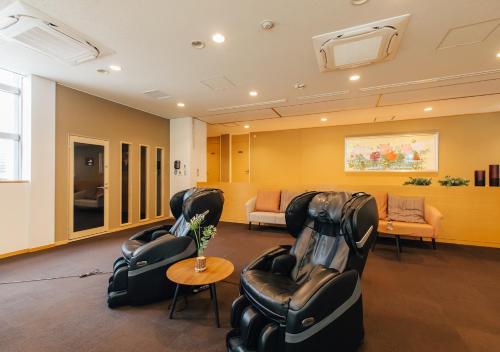a waiting room with black chairs and a table at Atami Fuga in Atami