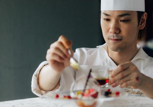 a man sitting at a table with a plate of food at Atami Fuga in Atami