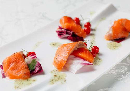 a plate of food with salmon and fruit on it at Atami Fuga in Atami