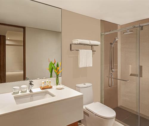 y baño con aseo, lavabo y ducha. en Pico Sands Hotel, en Nasugbu
