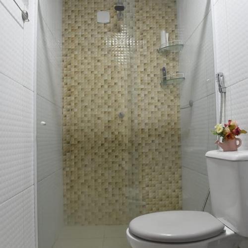 ein Bad mit Dusche, WC und Duschvorhang in der Unterkunft Bangalô lindo bem localizado em Jacumã in Conde