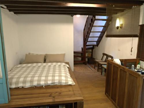 1 dormitorio con 1 cama en una habitación con escalera en Tree Element, en Jiufen