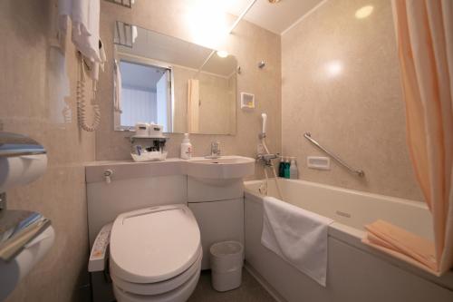 a bathroom with a toilet and a sink and a tub at Hotel Welview Kagoshima in Kagoshima