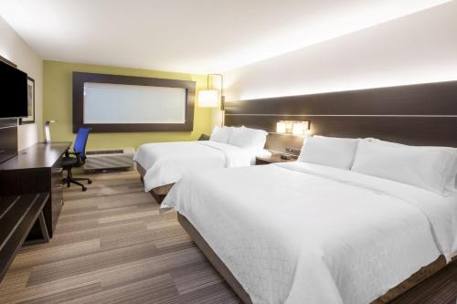 a hotel room with two beds and a flat screen tv at Holiday Inn Express & Suites Butler by IHG in Butler