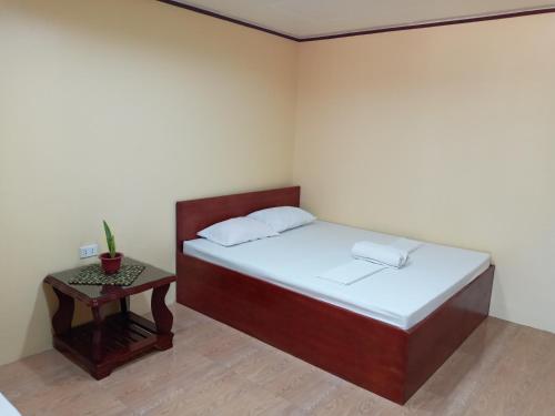 a small bedroom with a bed and a table at Vievan's transient house in Alaminos