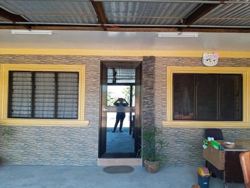 a person standing at the door of a house at Vievan's transient house in Alaminos
