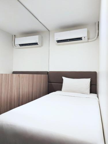 a bed in a small room with two windows at Anex Hotel near US Embassy in Manila
