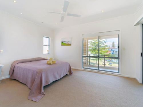 a bedroom with a bed and a large window at Bimbadeen Penthouse in Yamba