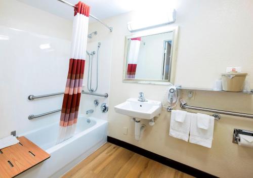a bathroom with a sink and a bath tub and a sink at Red Roof Inn Utica in Utica