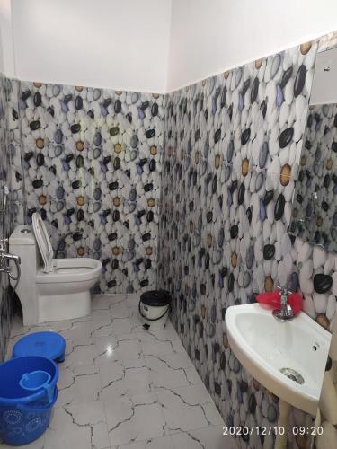 a bathroom with a toilet and a sink at MangalMurti Himalyan Homestay in Hawālbāgh
