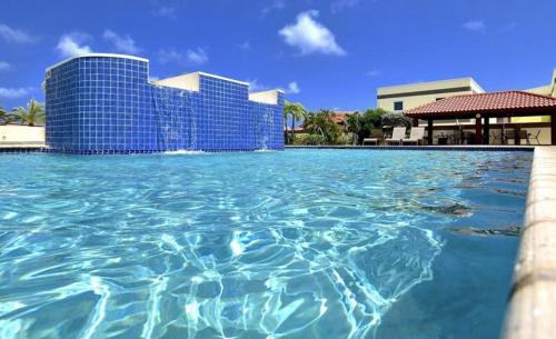 a pool of water in front of a building at Tranquil Eagle Beach Condo, sleeps 4 to 6 in Palm-Eagle Beach