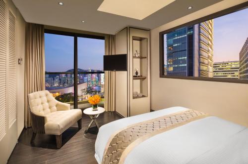 a hotel room with a bed and a large window at Hotel Pravo Hong Kong in Hong Kong