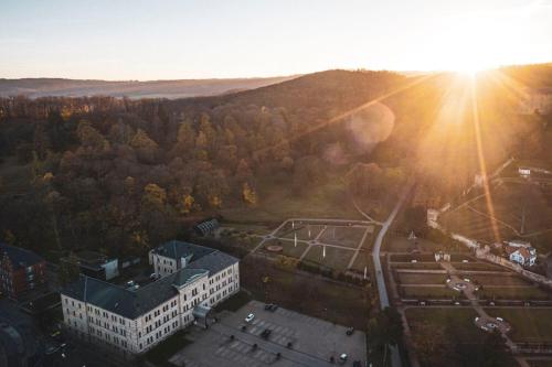 an aerial view of a building with the sun setting at Schlosshotel Blankenburg in Blankenburg
