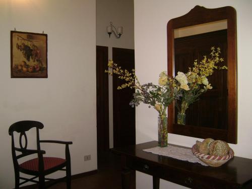 a table with a vase of flowers and a mirror at Ai Vecchi Crateri in SantʼAlfio