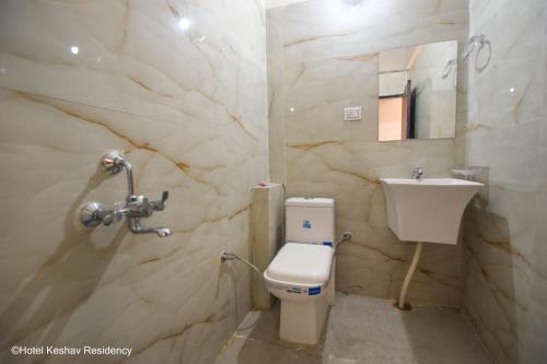 a bathroom with a white toilet and a sink at Hotel Keshav Residency in Chittaurgarh