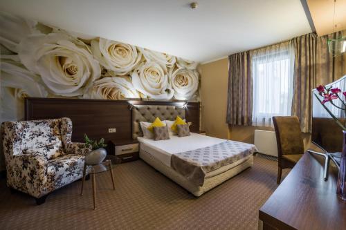 a hotel room with a bed and a chair at Business Hotel Plovdiv - Central Location in Plovdiv