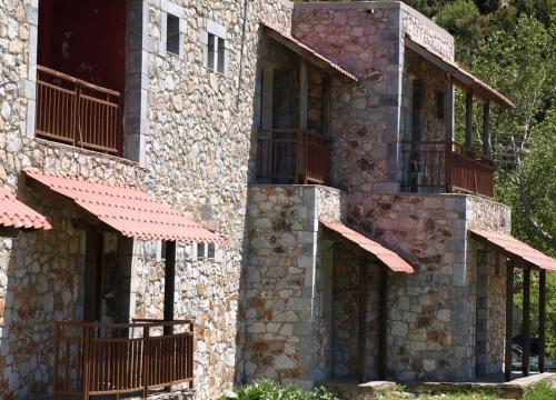 un edificio in pietra con balconi sul lato di To Exari a Omalos