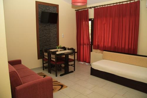 a living room with a bed and a dining room at Aphrodite in Keramotí