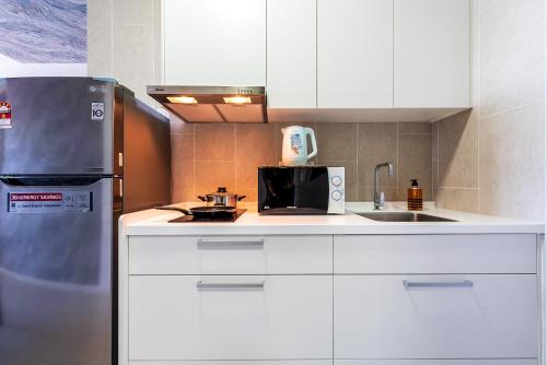 a kitchen with white cabinets and a refrigerator at Time To Relax v 3BR Geo Bukit Rimau,Shah Alam by Verano in Shah Alam