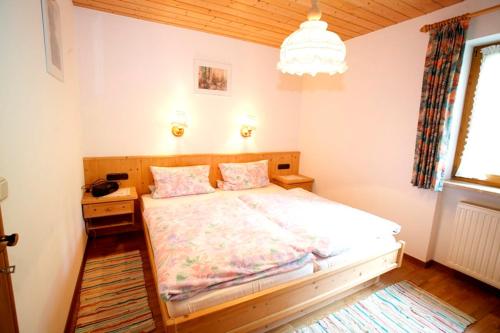 sypialnia z łóżkiem i żyrandolem w obiekcie Haus Krautloider w mieście Reit im Winkl