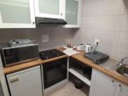 a kitchen with a counter with a microwave and a stove at Guesthouse Indongo Swakopmund in Swakopmund