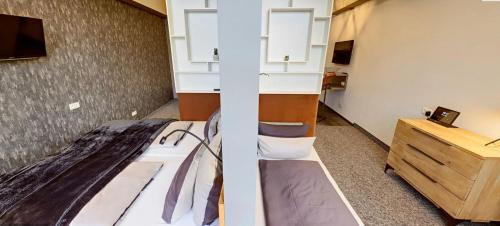 een kamer met een bed, een bureau en een televisie bij Boardinghouse Emden in Emden