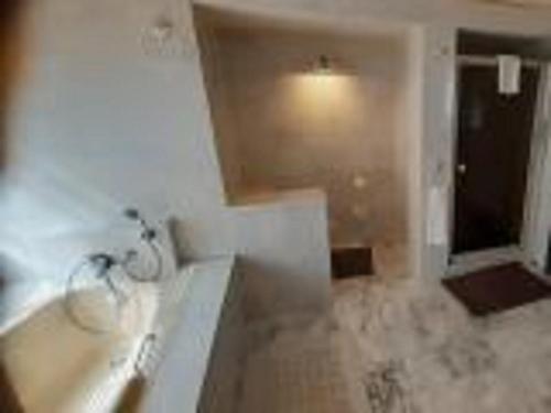 a bathroom with a tub and a sink and a window at Guesthouse Indongo Swakopmund in Swakopmund