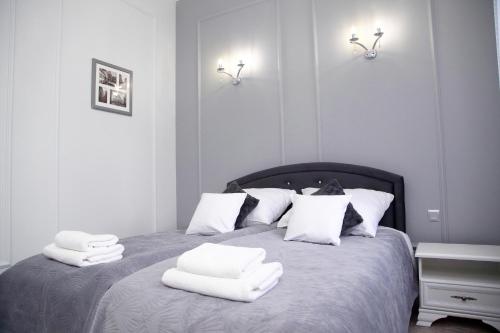 ein Schlafzimmer mit einem Bett mit weißen Handtüchern darauf in der Unterkunft Apartament Kryształowy in Toruń