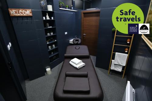 a bathroom with a bench and a toilet in a room at Perla Residence Hotel & SPA in Podgorica